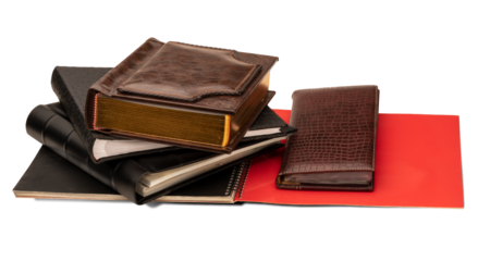 Stack of photo albums, business card holder and red spiral bound brochure isolated on a transparent background