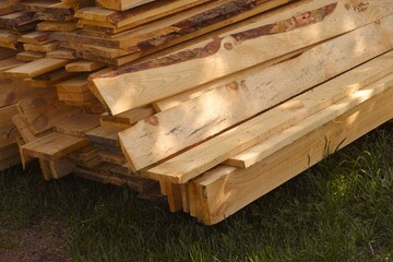A close-up shot of a stack of wooden boards on a grass
