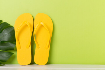 Bright yellow flip-flops on table. Summer concept