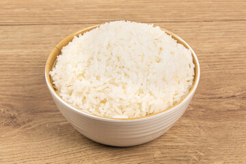 A bowl of plain white rice on a wooden table