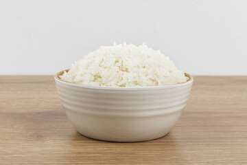 A bowl of plain white rice on a wooden table