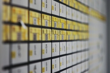 Detailed view of a wall completely covered in numerous yellow boxes, A calendar displaying upcoming deadlines and meetings