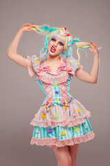 Pretty female clown model in colorful outfit and hair