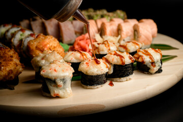 Huge sushi set in close up, capturing the moment of sauce seasoning.