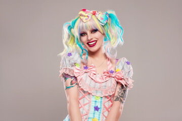 Portrait of pretty female clown in colorful outfit and hair