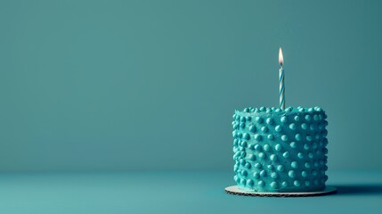   A blue birthday cake with one candle at its center, situated on a blue surface against a green background