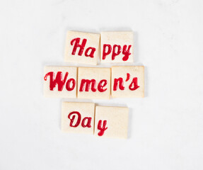 Women's Day. Modern delicate square cookies with marmalade filling of a thematic shape: Happy Women's Day. White background/ Top view