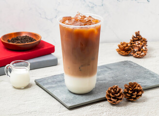Iced Black tea latte served in disposable glass isolated on board side view of taiwanese iced drink