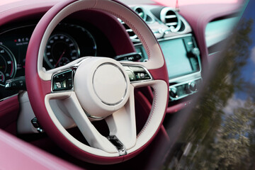 close-up of a leather steering wheel with white-pink leather in a luxury SUV