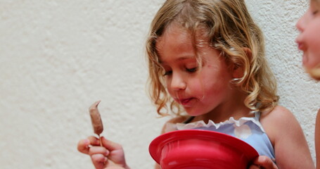 Candid small girl eating chocolate ice-cream