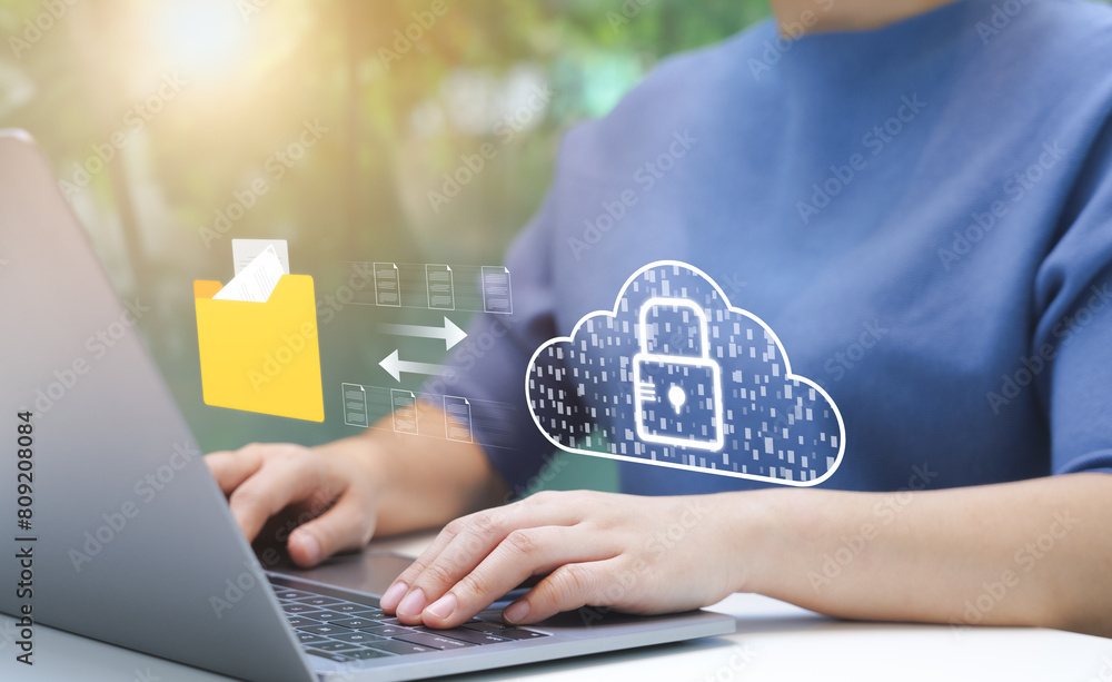 Poster person managing secure cloud data transfer. an individual uses laptop to manage secure data transfer