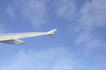 View of sky cloud and wing of airplane from window