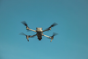 The UAV drone and photographer man hands. drone copter flying with digital camera. UAV Drone with...