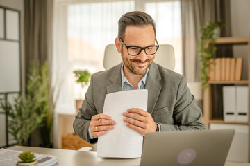 One men working in the office using technology and holding papers