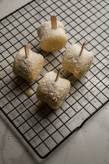 Metal grill grate with chocolate-covered macaroon in white chocolate