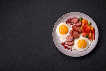 Delicious nutritious breakfast with fried eggs, sausage, steamed vegetables