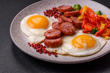 Delicious nutritious breakfast with fried eggs, sausage, steamed vegetables