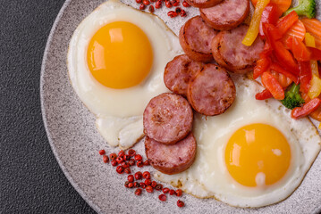 Delicious nutritious breakfast with fried eggs, sausage, steamed vegetables