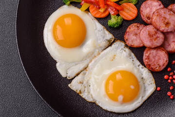 Delicious nutritious breakfast with fried eggs, sausage, steamed vegetables