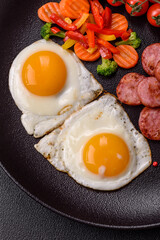 Delicious nutritious breakfast with fried eggs, sausage, steamed vegetables