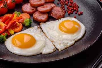 Delicious nutritious breakfast with fried eggs, sausage, steamed vegetables
