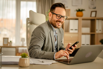 One men working in the office using technology holding a mobile phone