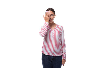 young brunette business woman dressed in a striped shirt looks at the camera on a white background