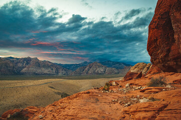 A thunderstorm drops sheets of rain in the mountains of Red Rock Canyon National Conservation Area, Nevada. In the foreground, burned stumps are evidence of recent wildfires.