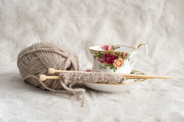 Knitting on knitting needles with teacup and saucer