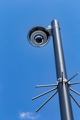 Security camera on a light pole on the street.Security camera and urban video in front of blue sky....