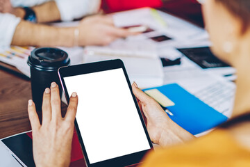 Cropped image of female hands typing text with finger on copy space display on modern touch...