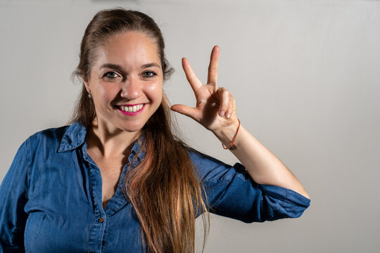 Mujer modelo haciendo el numero 3 con su mano. Fotograf&iacute;a de estudio con fondo blanco