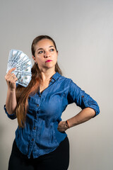 Mujer imponente sosteniendo mucho dinero. Fotografia vertical