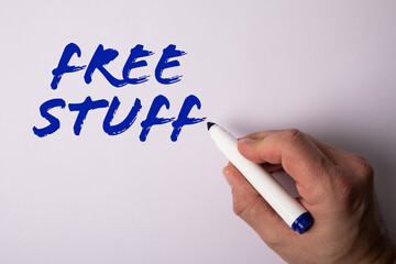 Free Stuff. Hand with marker writing text