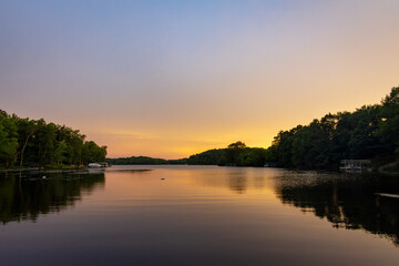 Obraz premium Looking onto a calm Wisconsin lake in the evening as the sun goes down.
