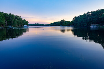 Obraz premium Looking onto a calm Wisconsin lake in the evening as the sun goes down.