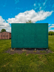 Empty wooden green board in a public park setting. Used for practicing sports or doing drills.