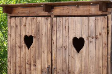 Close-up of the door of rural toilets with the symbol of hearts