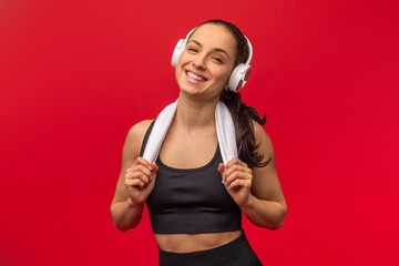 A woman is depicted wearing a sports bra while listening to music through headphones. She appears...