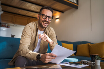 Portrait of adult caucasian man sit and hold paper work from home