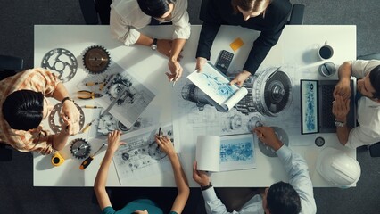 Top down aerial view of smart engineer team working together to design turbine engine. Professional...