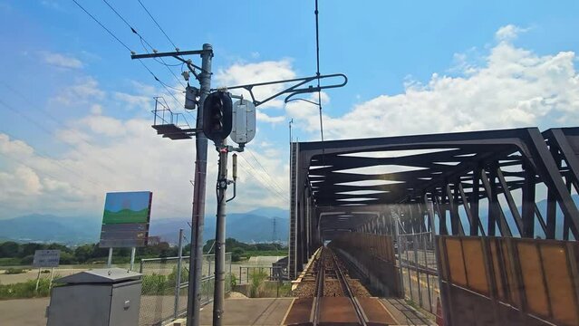 Train passing a bridge on countryside of Nagano, summer day in Japan