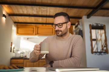 Portrait of adult men with eyeglasses sit on the table and hold cup