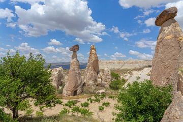 Dramatic landscape of Cappadocia Cavusin Valley, iconic fairy chimneys under a dynamic cloud-filled...
