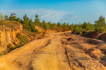 Red dust and mud road in poor condition with large holes