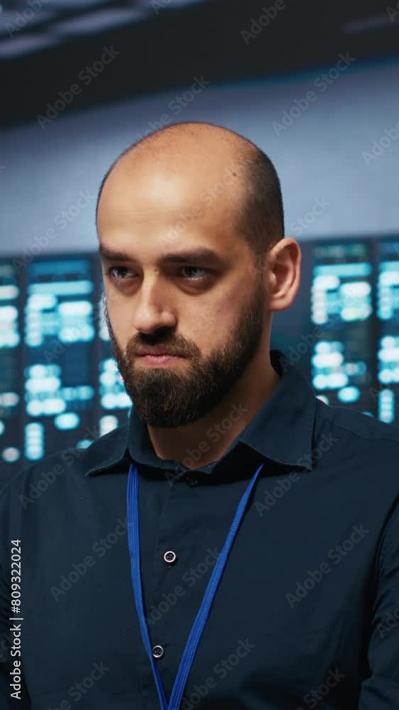 Poster vertical video computer scientist programming in data center room housing blade servers storing data