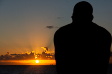 Fototapeta premium Silhouette of an unidentified person enjoying the sunset in the city of Salvador, Bahia.