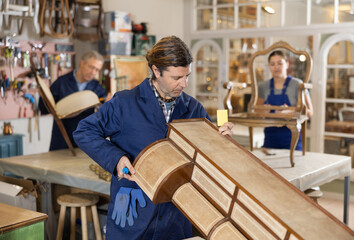 Male furniture workshop worker designing vintage chest of drawers