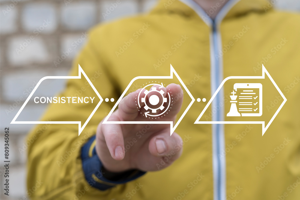 Poster man using virtual touch interface sees word: consistency. consistency key to success, focus business