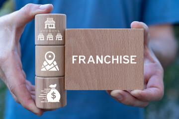 Man holding wooden blocks sees word: FRANCHISE. Franchise business concept. Franchise network...